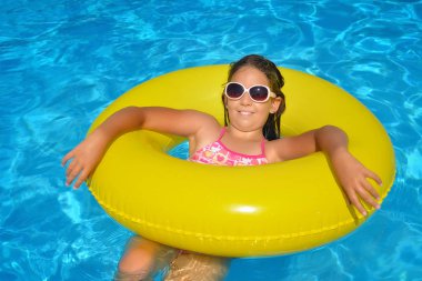 Çok tatlı bir kız, yüzme havuzunda dinleniyor, yaz tatili konsepti.