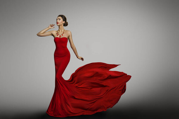 Woman Red Dress, Fashion Model in Long Silk Sexy Gown, Waving Flying Fabric Tail Train, Cloth Fluttering on Wind, Girl dancing over gray background