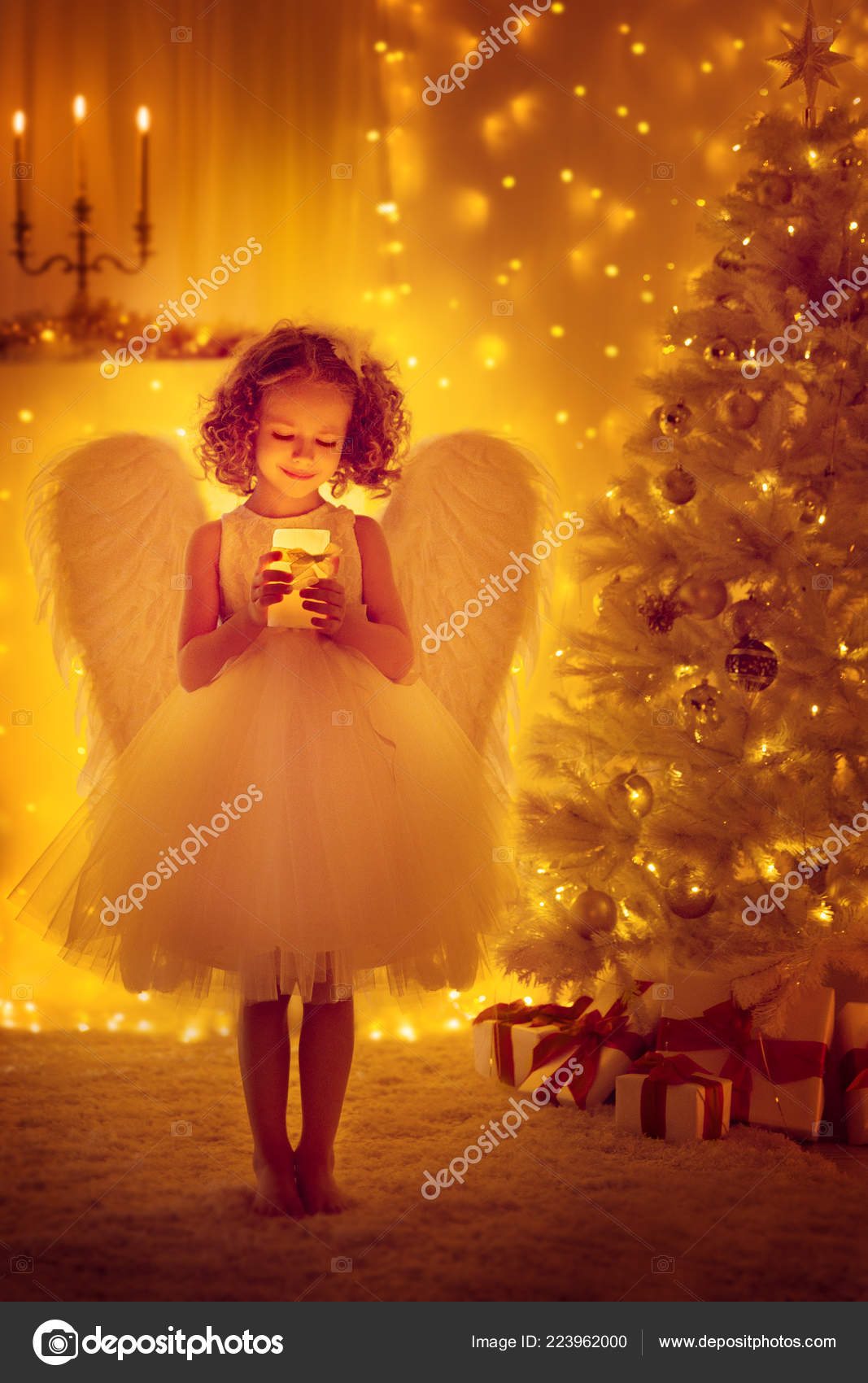 クリスマス天使翼児クリスマス ツリー 新年の夜の照明蝋燭前面を保持します ストック写真 C Inarik