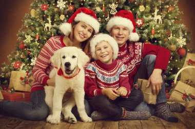 Noel aile ve köpek Xmas ağacı, mutlu anne baba çocuk portre kazak kırmızı Santa şapkalar altında