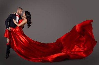 Kumaş sallayarak dans eden çift, kırmızı elbiseli kadına ve şık erkek takım, uçan 