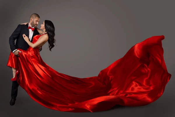 跳舞的夫妇 女人在红色礼服和优雅的男人在西装 飞行挥动的织品 — 图库照片