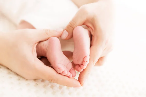 Pies del bebé recién nacido en las manos de la madre, masaje del pie del niño recién nacido — Foto de Stock