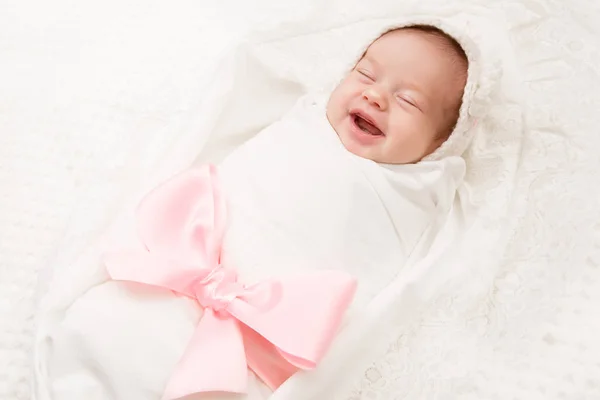 Nyfödda baby leende, nyfödd flicka leende insvept av Ribbon Bow — Stockfoto