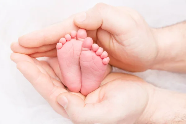 Pés de bebê recém-nascido, mãe segurando novas pernas de criança nascidas na mão — Fotografia de Stock