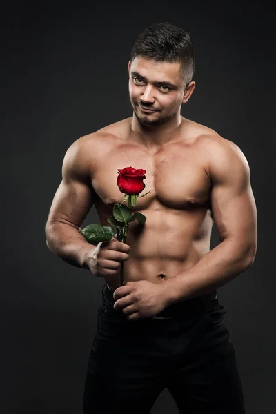 Sexy sportowiec człowiek z Rose Flower, atletyczny chłopiec muskularne ciało — Zdjęcie stockowe
