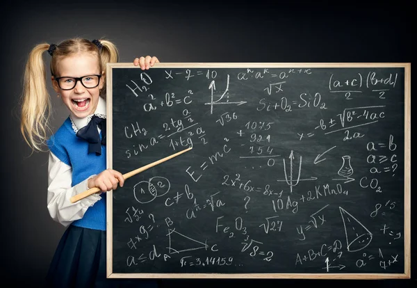 Criança menina apontando escola quadro negro com fórmulas de matemática — Fotografia de Stock