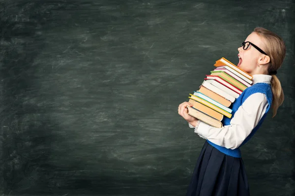 Verblüfftes Schulmädchen mit vielen Büchern, verblüfftes starkes Kind — Stockfoto