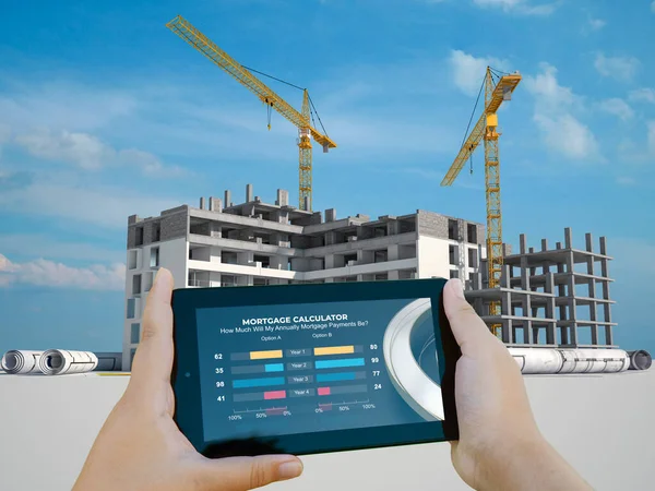 3D rendering of a mobile device with an mortgage calculator and an apartment building under construction