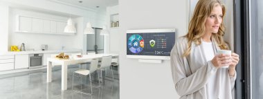 Modern bir evde ev otomasyon kontrol istasyonunda kahve içen bir kadın.