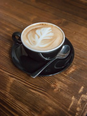 Tahta bir masada bir fincan kahve.