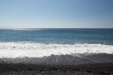 Dalgalar ve mavi gökyüzü ile deniz kıyısı
