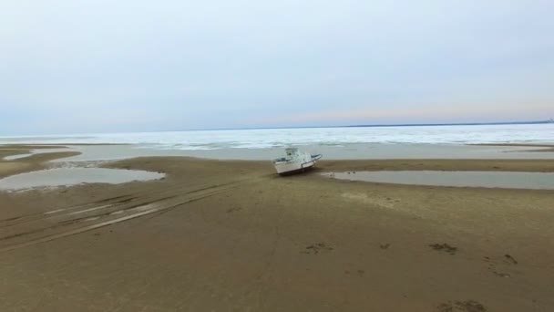 ビーチの上を飛んで空中ドローン クルーズ船や氷凍結した海の海岸に夕日を — ストック動画