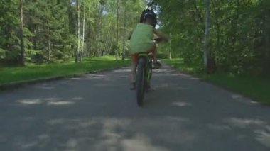 Küçük çocuk binicilik bisiklet hızlı güneşli bahar günü köyde.