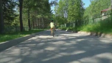 Kask binicilik bisiklet güneşli günde varoşlarda küçük çocuk.