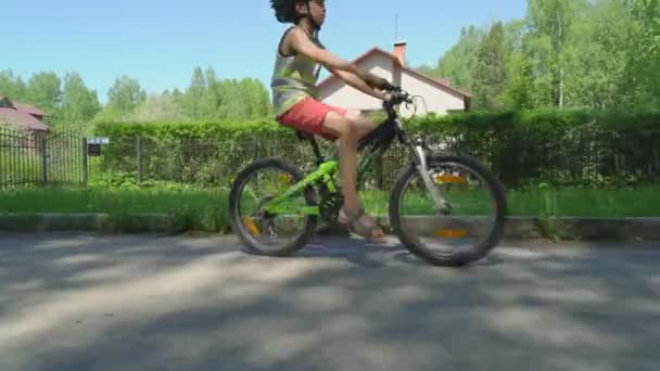 晴れた春の日に田舎でヘルメット乗馬の自転車では活発な男の子 — ストック動画