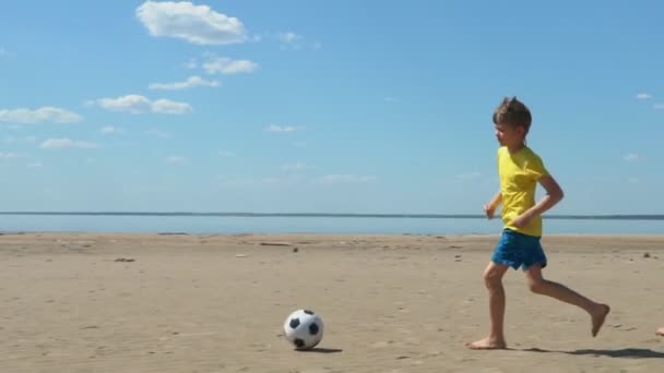 两个男孩在沙滩上踢足球慢动作 夏季户外活动 — 图库视频影像
