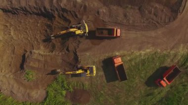 ağır makine ekskavatör ve inşaat sitesinde çalışan kamyonlar. Havadan görünümü.