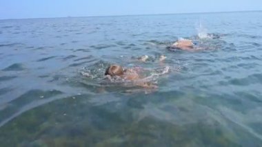 Mutlu çocuklar denizde yüzme. Çocuklar yaz tatili, aktif yaşam tarzı kavramı