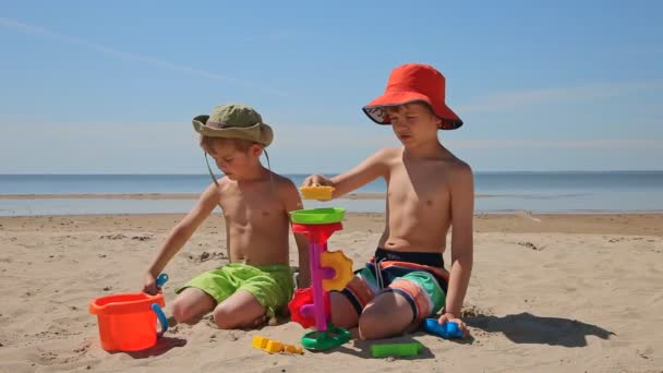 サンドミル浜辺で遊ぶ子供たち 夏の海で休暇子供 — ストック動画