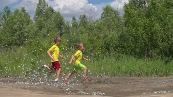Drei Jungen Rennen Sommertagen Mit Schmetterlingen Zeitlupe Über Die Landstraße — Stockvideo
