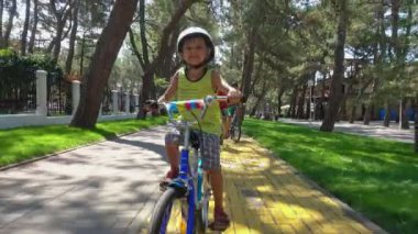 Çocuk Bisiklet Bisiklet yolu şehir park boyunca güneşli yaz gününde binmek.