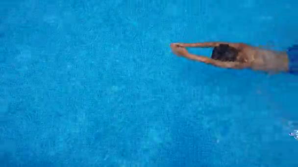 晴れた日にプールで泳いでいる少年 楽しみ — ストック動画