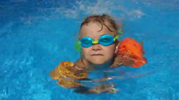 日当たりの良い夏の日に彼の兄弟とプールで泳ぐことを学ぶゴーグルの少年 — ストック動画