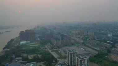 Havadan şehir yolları, nehir ve binalar görünümü. Gün batımında Novosibirsk şehrinde Smog & Pollution. Sibirya taiga orman yangınları sorunu.