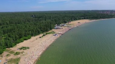 Güneşin altında yıkanan, denizde yüzen insanların havadan görünümü. Novosibirsk, Rusya'da yeşil orman yakınında otopark ile kum plajda Turistler.