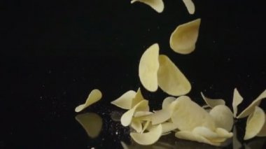 Siyah bir arka plan üzerine Düşen Patates Cipsi. Yavaş çekim.
