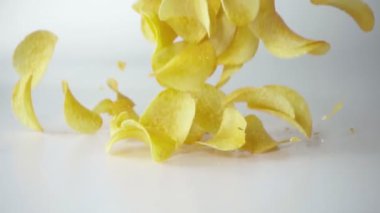 Yavaş çekim patates cipsi beyaz yüzeye düşüyor.
