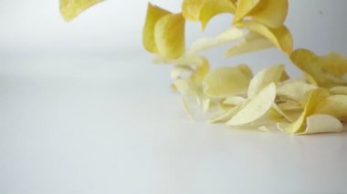 Beyaz arka planda Düşen Patates Cipsi. Yavaş çekimde yüksek hızlı kamera ile çekim.