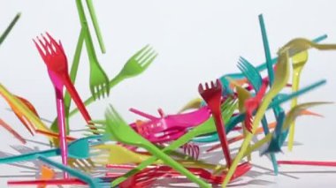 renkli plastik çatalbeyaz arka plan üzerinde yavaş hareket düşüyor