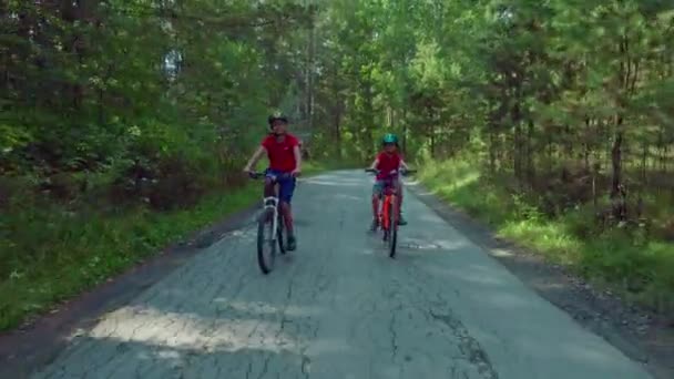在公园的路上骑着自行车的戴着头盔的小男孩 — 图库视频影像