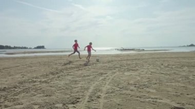 kum plajda futbol topu ile oynarken mutlu çocuklar eğitim