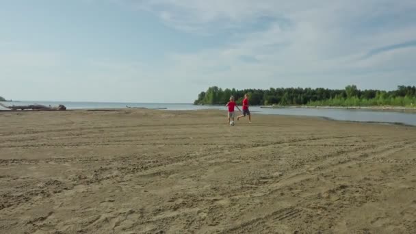 Dos Chicos Corriendo Jugando Con Pelota Fútbol Playa Arena Cámara — Vídeos de Stock