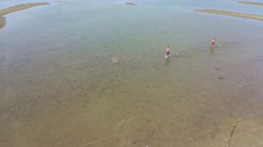 Sığ deniz suyunda çalışan iki çocuğun havadan görünümü, yaz tatilleri