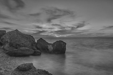 Alacakaranlıkta kayalık Kato Petres Sahili manzarasında uzun pozlama. Rodos, Yunanistan