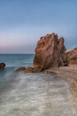 Alacakaranlıkta kayalık Kato Petres Sahili manzarasında uzun pozlama. Rodos, Yunanistan