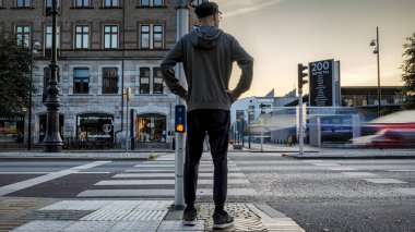 HELSİNGBORG, SWEDEN - 25 Eylül 2020: Akşam karanlığında uzun pozlu bir fotoğraf, bu arada bir yaya yolu geçmek için bekliyor.