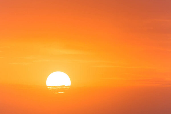 view on sun rising behind slight clouds