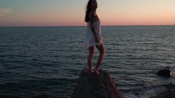 VACANZA ROMANTICA SUL MARE. Giovane signora guarda e sorpreso dal tramonto . — Video Stock