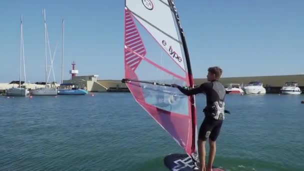 Desportistas jovens de folha de vento começam a deslizar a superfície da água. WINDFOIL SURROUNDED PELA YACHT . — Vídeo de Stock