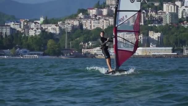 Helle Wassersportler fahren Windsurfen. Aktivurlaub am Meer. Wassersport erkunden. — Stockvideo