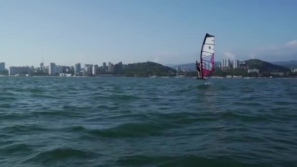 Jóvenes deportistas acuáticos se deslizan a través de la costa moderna a horisont. Los hombres guapos disfrutan de deportes acuáticos. Explorando el papel de viento. Vacaciones activas en el mar . — Vídeo de stock