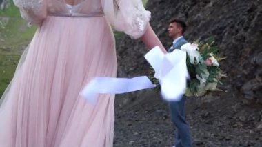 Boho stili pembe weddind elbise, Gelin Buketi wight şeritler tutar. Düğün dağlarda.