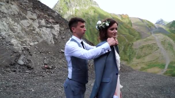 Sposo delicato vestire sposa a giacca mentre lei gentilmente sorriso. Matrimonio Boho. Cerimonia nuziale all'aperto . — Video Stock