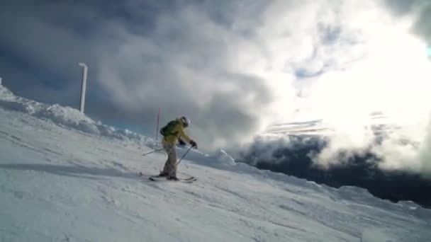 Ženské lyžař jede přes okraje hory před fascinující Xxxx mraky. — Stock video