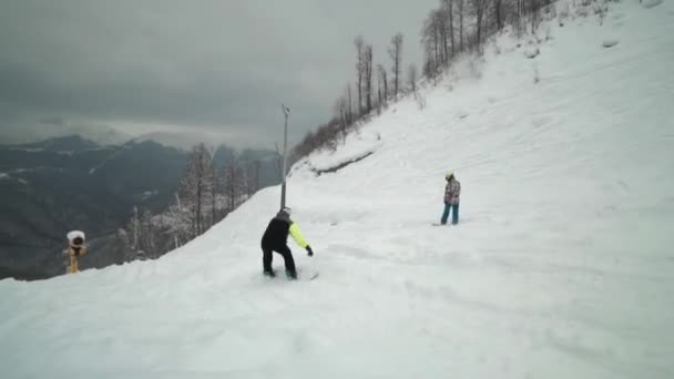 Snowboard sürmek kesin olmayan biçimde Kayak Merkezi, taze kar üzerinden kayma. Bulutlu ve sisli hava Kayak Merkezi. Dağları çevrili snowboard sürmek büyüleyecek. — Stok video